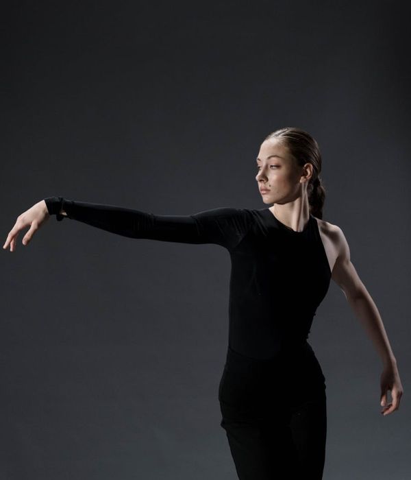Woman performing a graceful mobility yoga pose indoors.